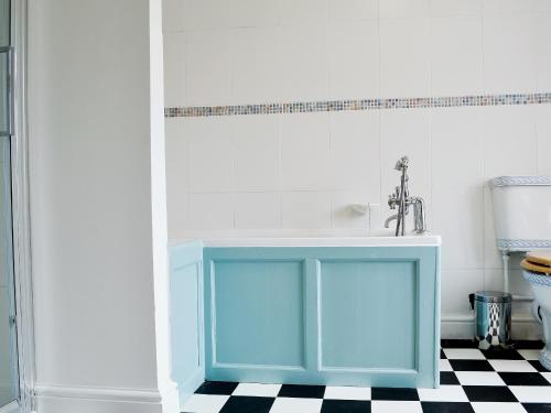 a bathroom with a blue cabinet and a sink at Lordship Farmhouse in Saint Lawrence