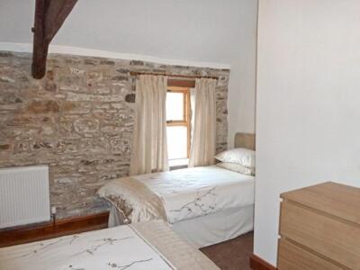a bedroom with two beds and a window at Lord Mayors Barn in Alston