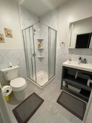 a bathroom with a shower and a toilet and a sink at Modern Luxury Apartment near NYC in Jersey City