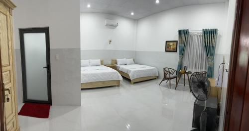 um quarto com 2 camas, uma mesa e uma cadeira em Thanh Mai House Phú Quốc em Phu Quoc