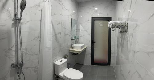 uma casa de banho com um WC, um chuveiro e um espelho. em Thanh Mai House Phú Quốc em Phu Quoc