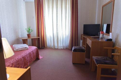 a hotel room with a bed and a television at Laetu in Atyraū