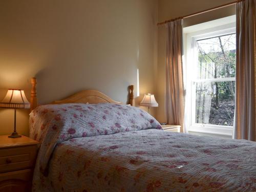 1 dormitorio con cama y ventana en Pegs Place, en Windermere