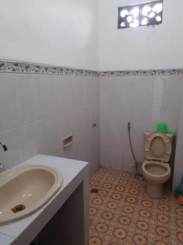 a bathroom with a sink and a toilet at Wisma Galiharum Banjarnegara in Banjarnegara