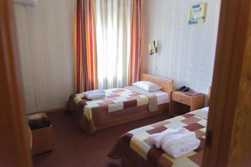 a hotel room with two beds and a window at Laetu in Atyraū