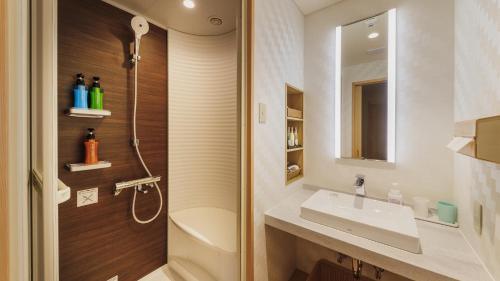 a bathroom with a toilet and a sink and a shower at Tendo Hotel in Tendo