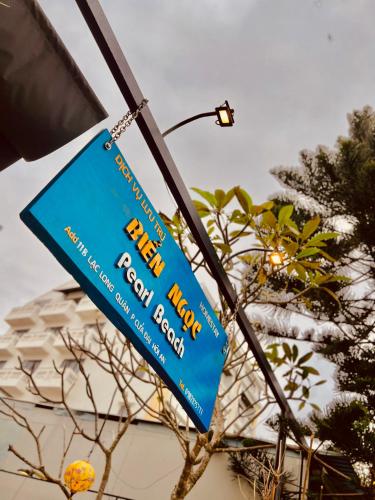 a blue sign hanging from a street light at Pearl Beach Homestay - Cua Dai Beach, Hoi An in Hoi An