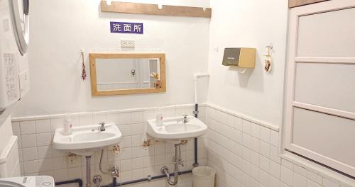 a bathroom with two sinks and a mirror at ペンションやいま日和 in Ishigaki Island
