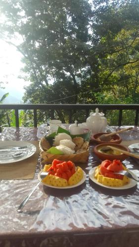 エッラにあるSadew Home Stayのテーブルの上に食べ物の皿が置かれている