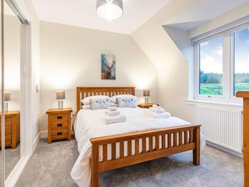 ein Schlafzimmer mit einem großen Bett und einem Fenster in der Unterkunft Gartclach-uk40001 in Gartmore