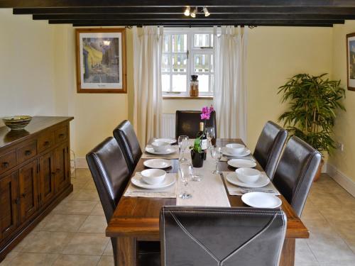 a dining room with a table and leather chairs at Well Cottage in Luxborough