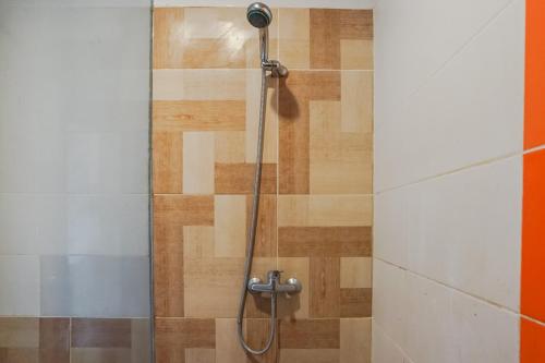 a shower in a bathroom with a wooden floor at Akarsa Kokoro in Sanur