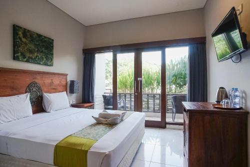 a bedroom with a large bed and a large window at Akarsa Kokoro in Sanur