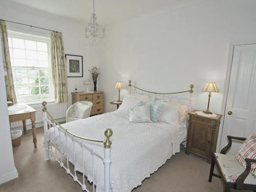 a white bedroom with a white bed and a chair at West View Cottage - E5386 in Two Dales