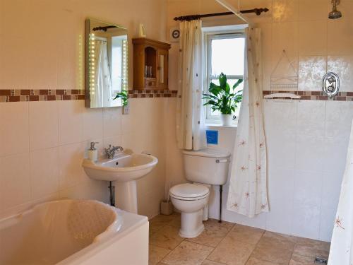 a bathroom with a sink and a toilet and a tub at Meadow View - Ijv in Brigham