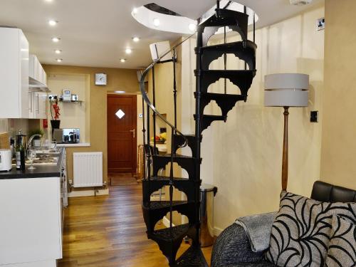 a black spiral staircase in a living room at The Tiny Terrace in Llandybie
