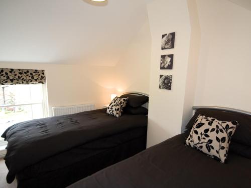 a bedroom with two beds and a window at Somer Leyton Cottage in Chapel Saint Leonards