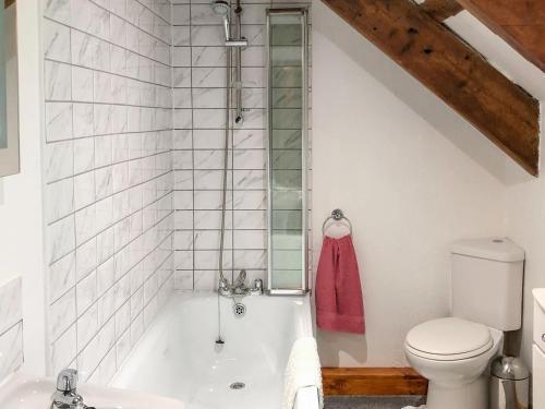 a bathroom with a bath tub and a toilet at Lletty Cottage in Capel-Ifan