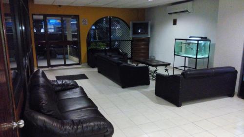 una sala de estar con sofás de cuero y una pecera. en Hotel y Restaurante Ritz de Tabasco, en Villahermosa