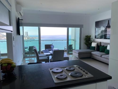a kitchen and living room with a view of the ocean at Torre EME Department in Mazatlán