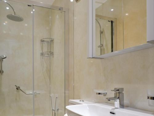 a bathroom with a glass shower and a sink at Railway Cottage in Brassington