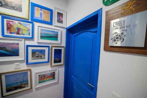 a blue door in a room with pictures on a wall at Casa María in Isla Mujeres
