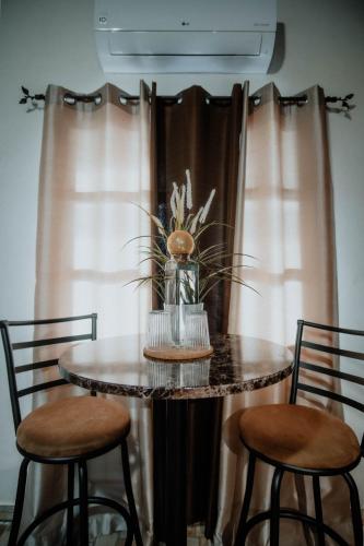 a table with two chairs and a table with a vase at Cabaña R y A Valle de Guadalupe in Valle de Guadalupe