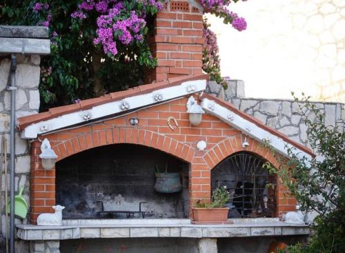 a brick oven with two cats on top of it at Room Eufemija-Rab in Rab