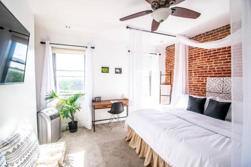 a bedroom with a large bed and a brick wall at The Hidden Paradise Home Studio, Downtown City Views, Productions, Families & Large Groups in Baltimore