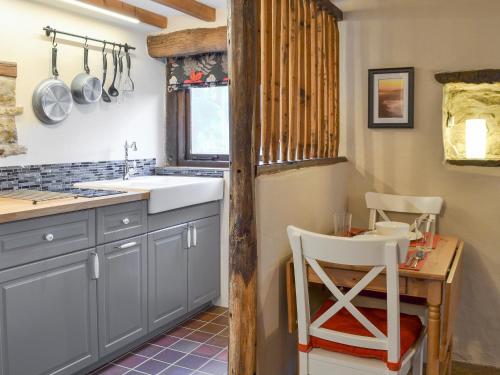 a kitchen with a sink and a table with a chair at The Old Stable in Edale