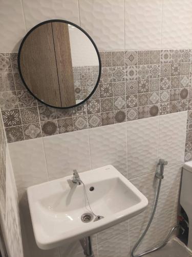 La salle de bains est pourvue d'un lavabo et d'un miroir mural. dans l'établissement Home Boss, 