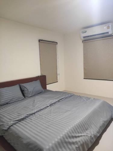 a bedroom with a bed and a window with a air conditioner at Home Boss 