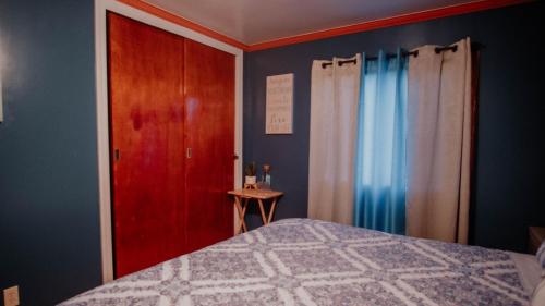 a bedroom with a bed and a wooden door at Cabaña R y A Valle de Guadalupe in Valle de Guadalupe