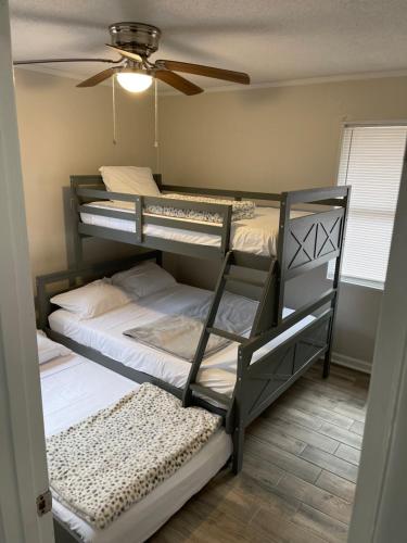een slaapkamer met 2 stapelbedden en een plafondventilator bij Beyond Comfort in Hinesville