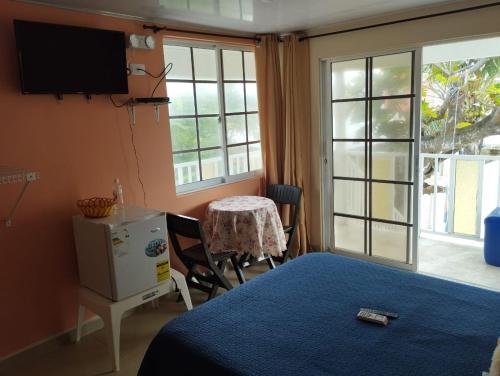 sypialnia z łóżkiem, stołem i oknem w obiekcie South Beauty w mieście San Andrés
