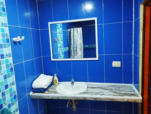a blue bathroom with a sink and a mirror at South Beauty in San Andrés