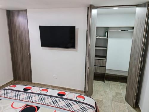 Habitación con TV de pantalla plana y cama. en Aparta Estudio 2 Camas - Parqueadero para Moto - Ibagué - Ciprés, en Ibagué