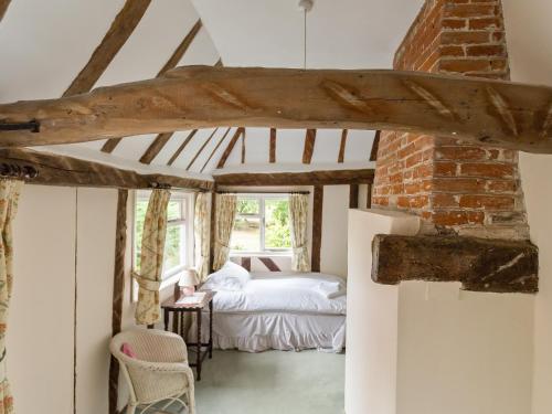 um quarto com uma cama e uma janela em Old High Hall em Cowlinge