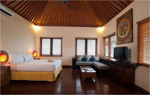 a bedroom with a bed and a couch and a tv at 6BR Villa Sensel - Minggu Villas Seminyak in Seminyak