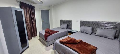 a hotel room with two beds and a television at Best Dreams Hotel in Cairo