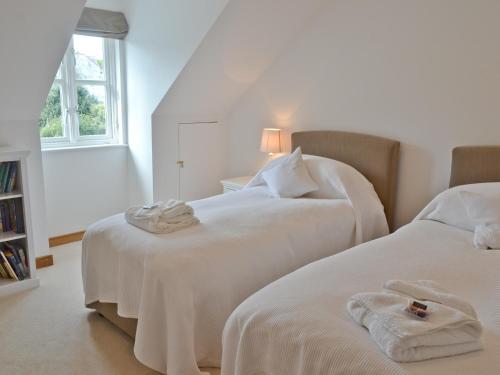 two white beds in a room with a window at Gylly Beach View - Tor in Falmouth