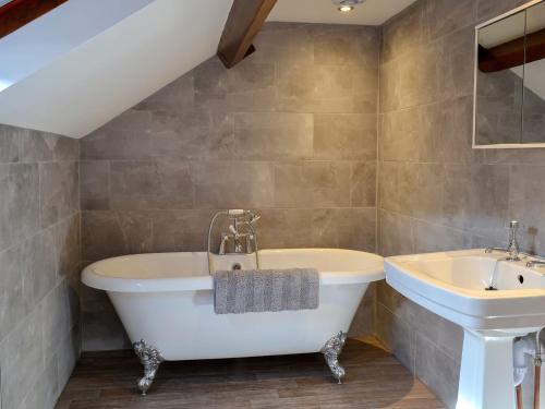 a bathroom with a tub and a sink at Whisperdale Barn in Broxa