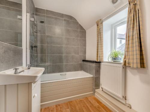 a bathroom with a tub and a sink and a shower at 2 Cromwells Cottage-uk40929 in Pembroke