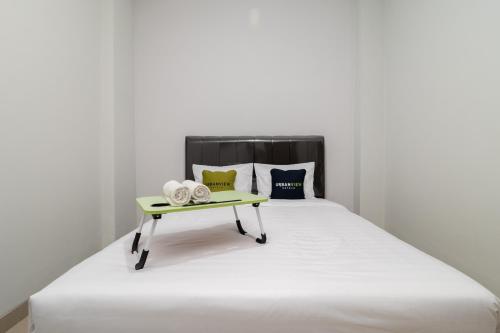 ein Bett mit einem gelben Tablett darüber in der Unterkunft Urbanview Hotel Pasar Baru Jakarta by RedDoorz in Jakarta