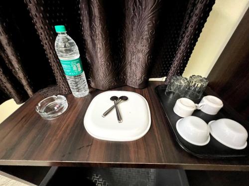 a wooden table with a sink and a bottle of water at Hotel East park Electronic City in Bangalore