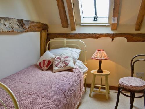 1 dormitorio con 1 cama y 1 lámpara en una mesa en Mount House Barn, en Burwash