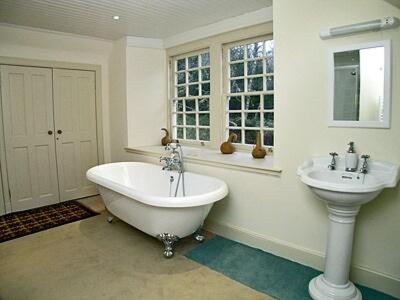 a white bathroom with a tub and a sink at Forget Me Not - Skkz in Dalmellington