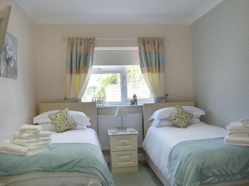1 dormitorio con 2 camas y ventana en The Annexe, en Clacton-on-Sea