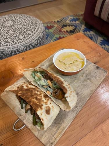 a wooden table with two tacos and a bowl of soup at Francolin Lodge-Farmstay @ Darima in Mukteswar