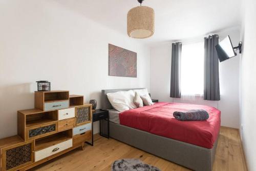 1 dormitorio con 1 cama con colcha roja en NEW ShalalaLiving Vienna - Lovely Family Home near Schönbrunn - PG, en Viena
